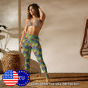 A model wearing frog leggings depicting an all-over print of multicoloured strawberry poison frogs on a green background.
